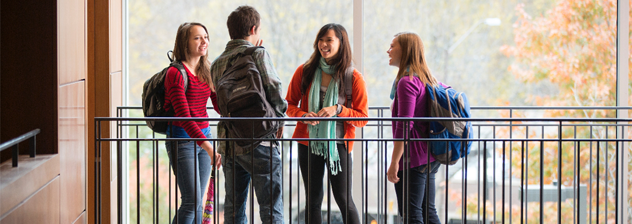 Several students standing around a railing