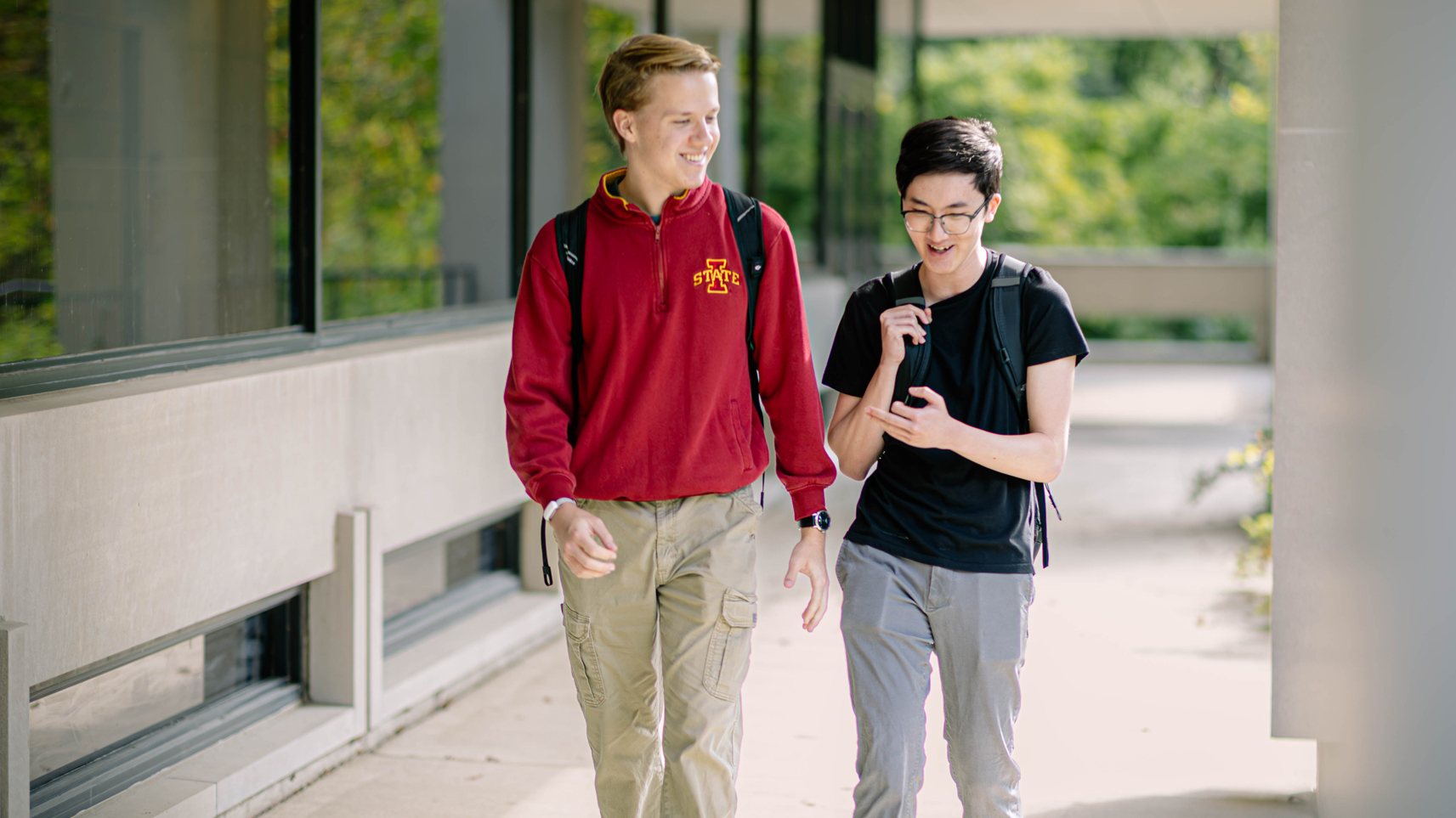 Two Iowa State Students walking while talking outside Carver hall